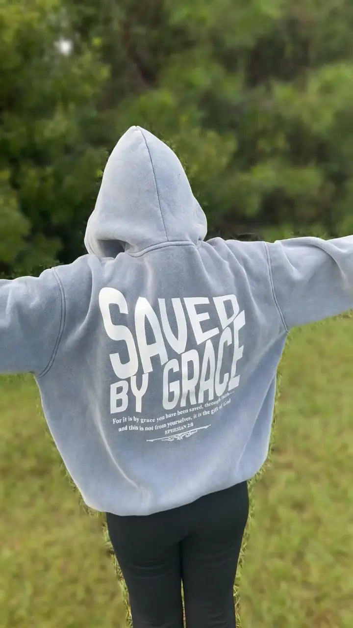 Back of the Saved by Grace hoodie in original footage with subtle background blur
